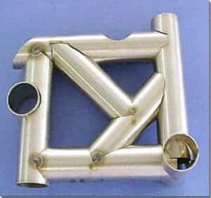 Intricate laser-cut metal assembly made from tubes of varying diameters against a blue background, showcasing high-precision tube laser cutting services.